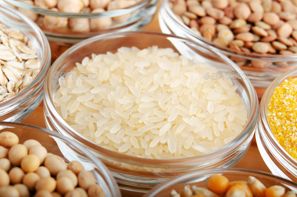 Rice closeup in glass bowl on wooden kitchen table, non-perishable, long shelf life food concept