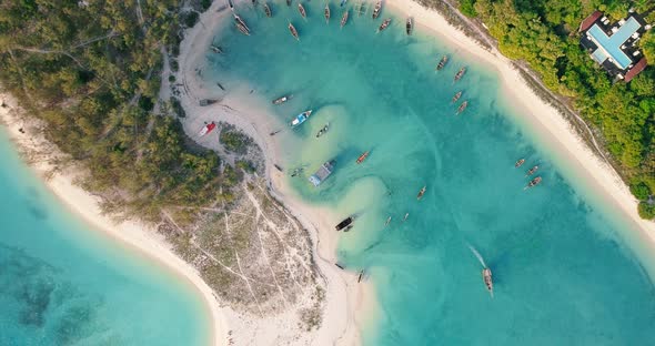 Aerial view of the fishing boats on tropical sea coast with sandy beach at sunset. Summer 