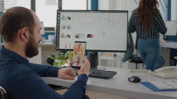 Invalid Businessman in Wheelchair Discussing with Friends on Video Call alt