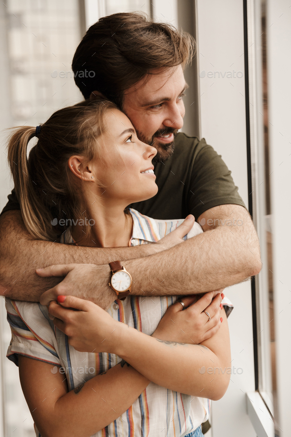 Photo of romantic cute couple smiling and hugging while standing Stock  Photo by vadymvdrobot