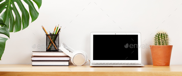 Stylish home studio workspace with laptop, supplies and headphones - Stock Photo - Images