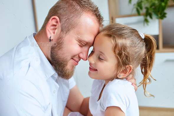 Adorable little girl in white dress hugging loving father - Stock Photo - Images