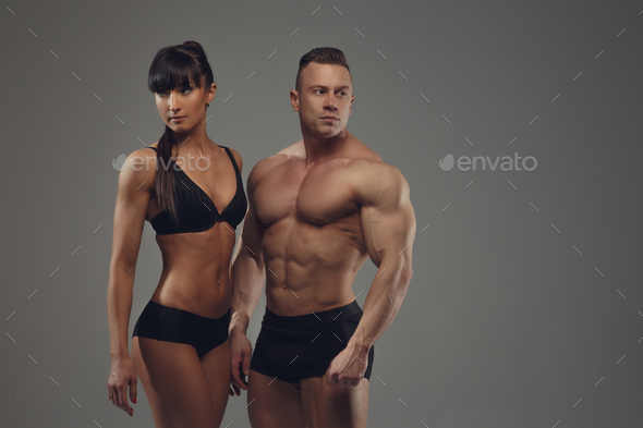 Fitness couple isolated on a grey background. Stock Photo by fxquadro