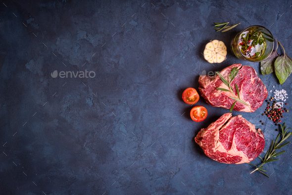 Raw meat steak on rustic concrete background ready to roasting - Stock Photo - Images