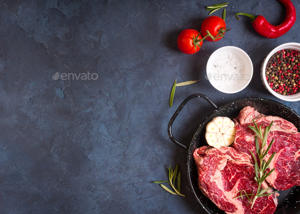 Raw meat steak on rustic concrete background ready to roasting - Stock Photo - Images