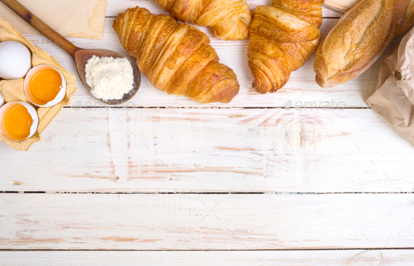 Croissants, baguette, flour, eggs background - Stock Photo - Images