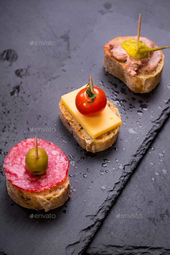Spanish tapas on a black stone - Stock Photo - Images