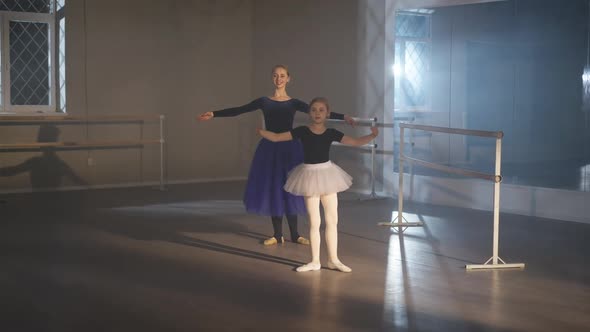Wide Shot of Motivated Charming Pretty Little Ballerina and Gorgeous Woman Rehearsing Tendu Eleve alt