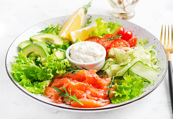 Salad of salted fish salmon, avocado, cherry tomatoes, cucumber, lettuce and cream cheese.