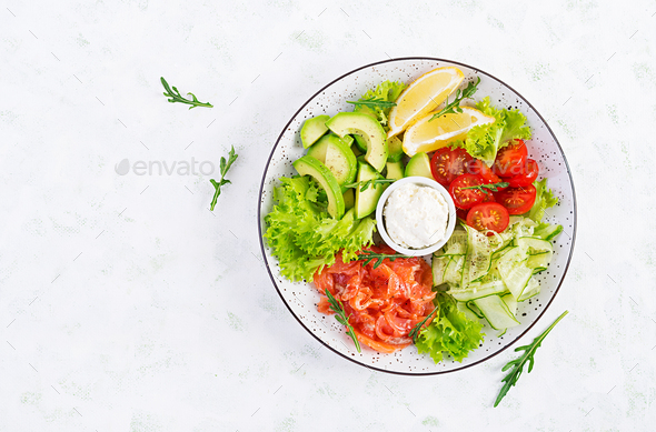 Salad of salted fish salmon, avocado, cherry tomatoes, cucumber, lettuce and cream cheese. - Stock Photo - Images