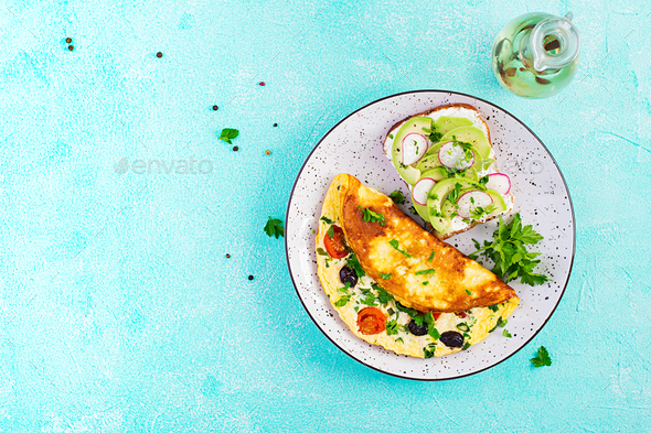 Omelette with tomatoes, black olives and sandwich with avocado - Stock Photo - Images