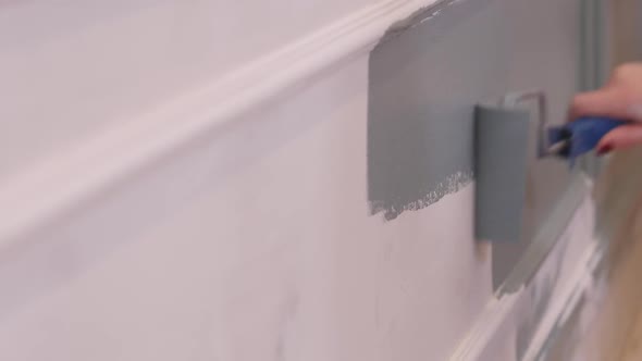 Woman Painter Paints Wall Indoors By Paint Roller And Paint