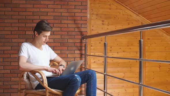 Young Businessman Works Using Laptop at Home.