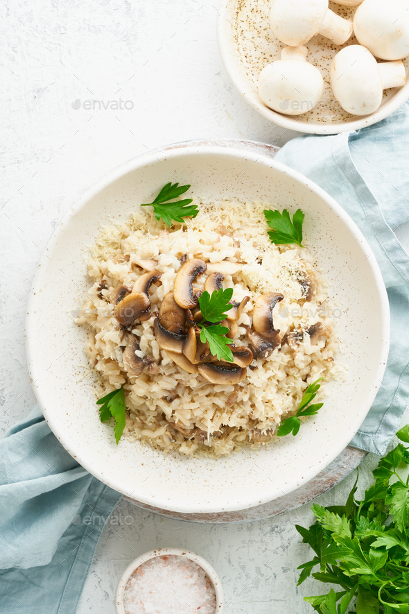 Risotto with mushrooms in plate. Rice porridge with mushrooms and parsley - Stock Photo - Images