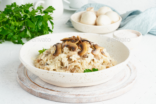 Risotto with mushrooms in plate. Rice porridge with mushrooms and parsley - Stock Photo - Images