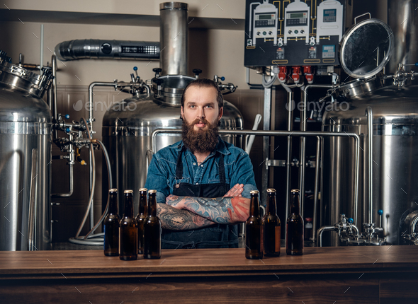 A man manufacturer presenting beer in the microbrewery. - Stock Photo - Images