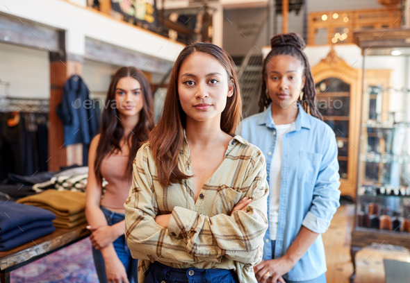 Portrait Of Multi-Cultural Female Sales Team In Fashion Store Standing In Front Of Clothing Display