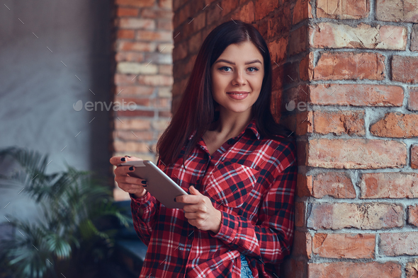 Portrait of a charming brunette in a flannel shirt and jeans wit Stock ...