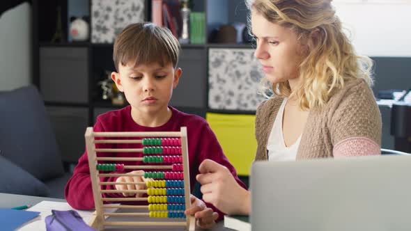 Video of mother teaches her son to count with an abacus. Shot with RED helium camera in 8K. alt