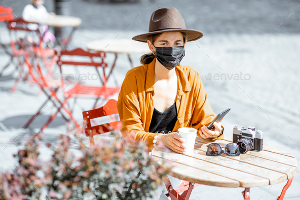 Woman in facial protective mask at the cafe outdoors - Stock Photo - Images