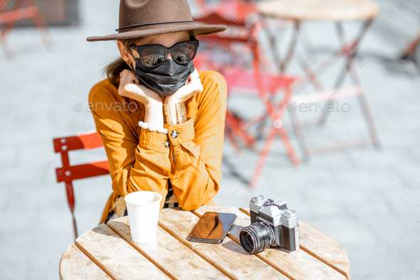 Woman in facial protective mask at the cafe outdoors - Stock Photo - Images