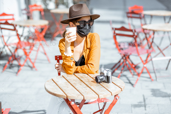 Woman in facial protective mask at the cafe outdoors