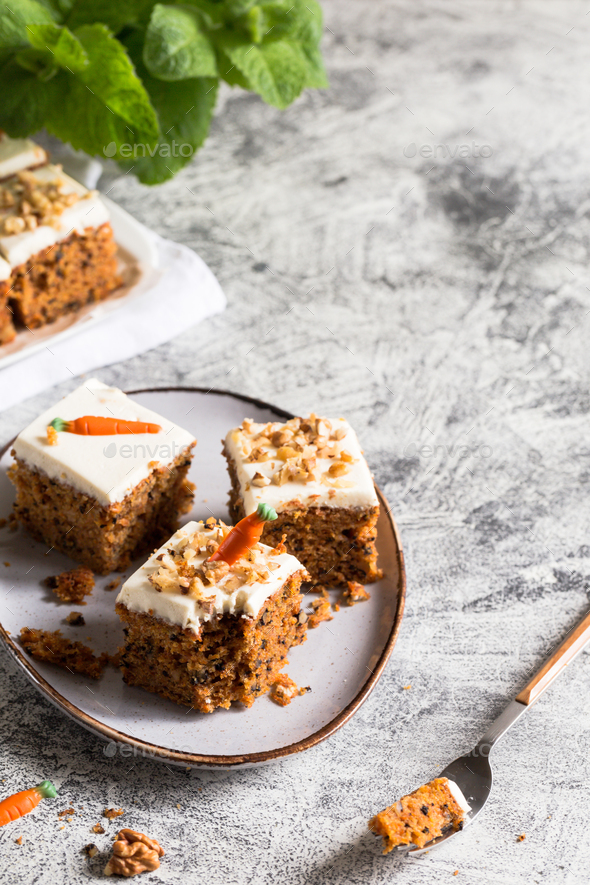 pieces of carrot cake with walnuts with icing cream