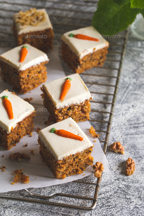 pieces of carrot cake with walnuts with icing cream