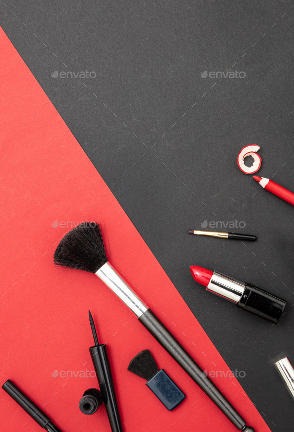 Make-up cosmetics accessories against red and black background - Stock Photo - Images