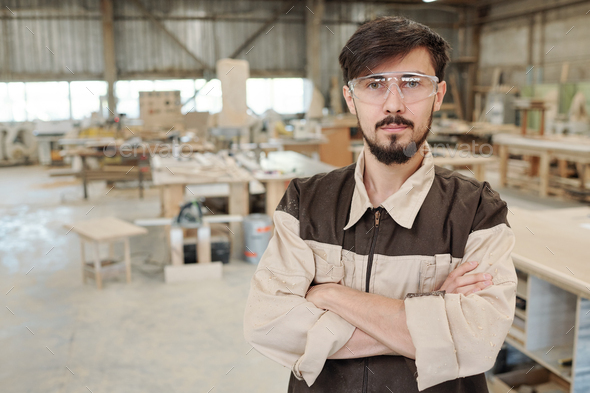Young serious worker or engineer of furniture producing factory in uniform - Stock Photo - Images