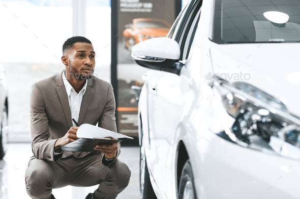 African Man Sitting Near New Vehicle Checking Auto In Store - Stock Photo - Images