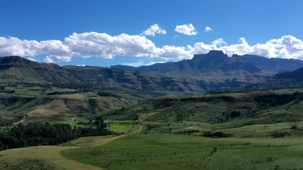Time-lapse of lush green valley and blue mountains with fast moving clouds over Drakensberg Mountain alt