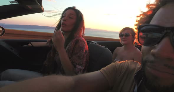 Handsome black man partying with friends while driving in convertible alt