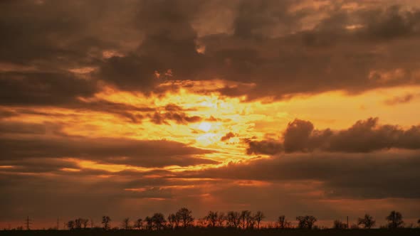 Heavy Clouds Float Across Sky at Picturesque Orange Sunset