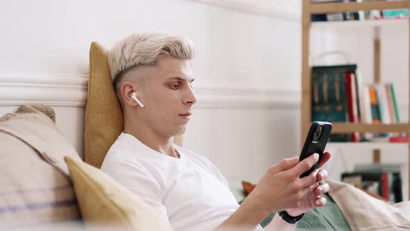 Young Man Using Smartphone and Headphones alt