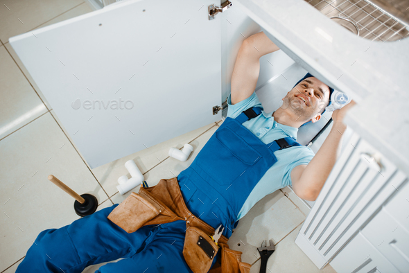 Plumber in uniform installing drain pipe, top view - Stock Photo - Images