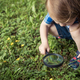 Happy little boy exploring nature with magnifying glass at the day time - PhotoDune Item for Sale