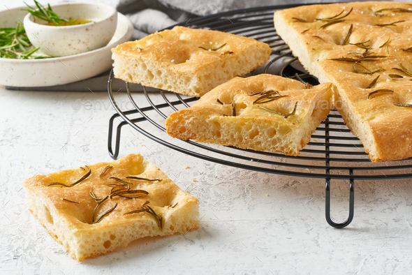 Focaccia, pizza, italian flat bread with rosemary and olive oil on grid - Stock Photo - Images