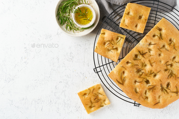 Focaccia, pizza, italian flat bread with rosemary and olive oil on grid - Stock Photo - Images