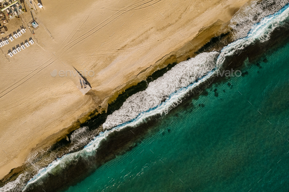 Aerial view of sand meeting the sea water and waves