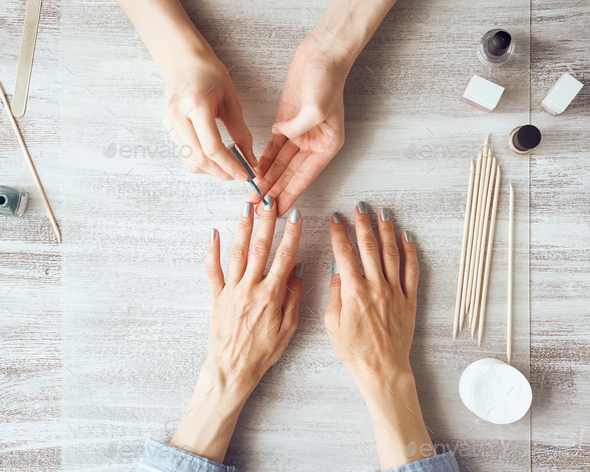 Mother and daughter do manicure, paint nails with varnish. Home self-care during quarantine