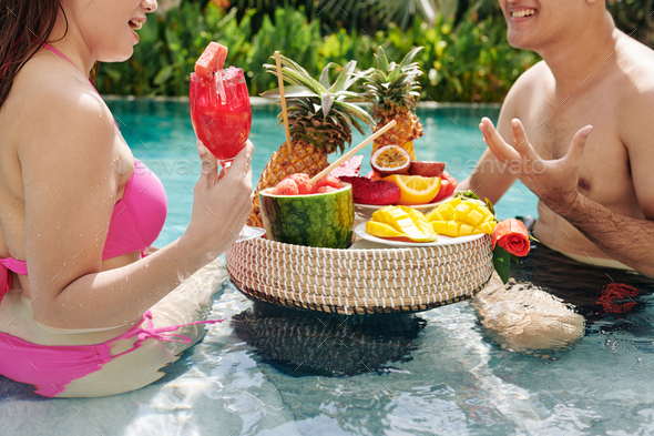 Couple enjoying fruits in swimming pool