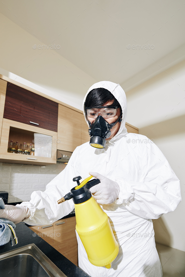 Worker spraying antiviral and antibacterial spay - Stock Photo - Images