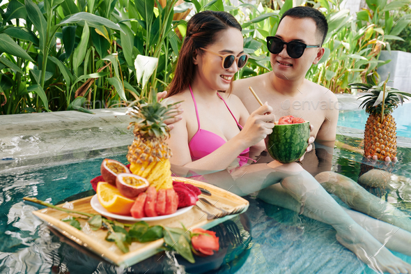 Smiling couple resting in small pool - Stock Photo - Images