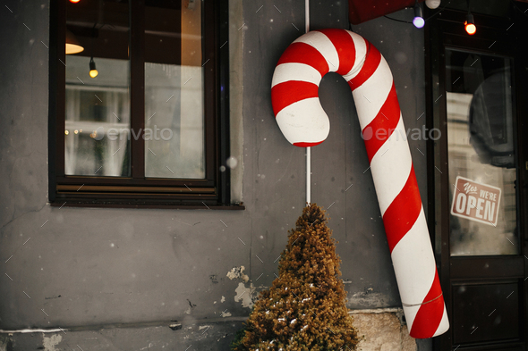 Christmas street decor. Stylish christmas big candy cane toy at store front