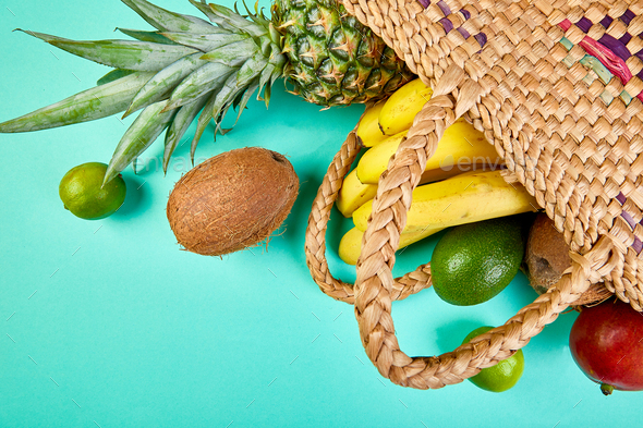Grocery shopping bamboo bag with organic exotic fruits on blue background. - Stock Photo - Images