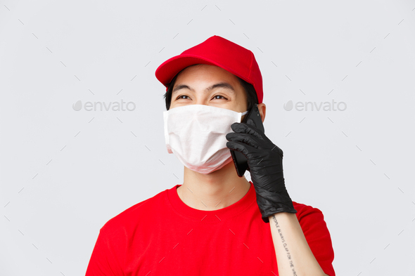 Covid-19, self-quarantine online shopping and delivery concept. Friendly young asian courier in - Stock Photo - Images