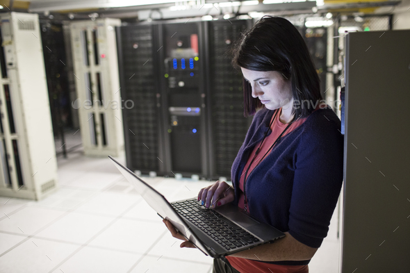 Caucasian woman technician in a large computer server farm. - Stock Photo - Images