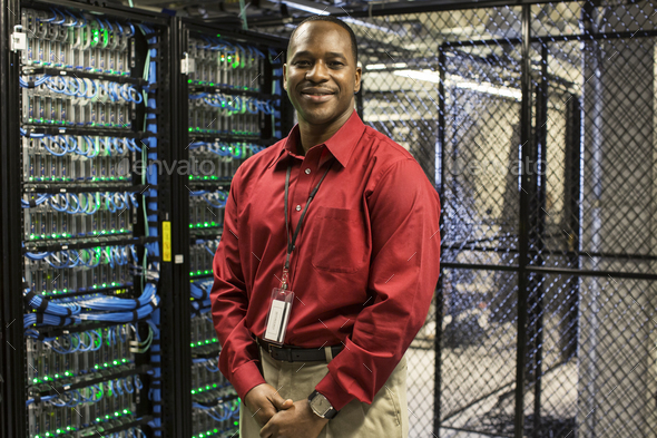 Black man technician in a computer server farm.