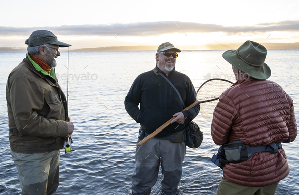 Two fly fisherman talk wtih their guide about new tecnhiques while fly fishing for searun coastal - Stock Photo - Images